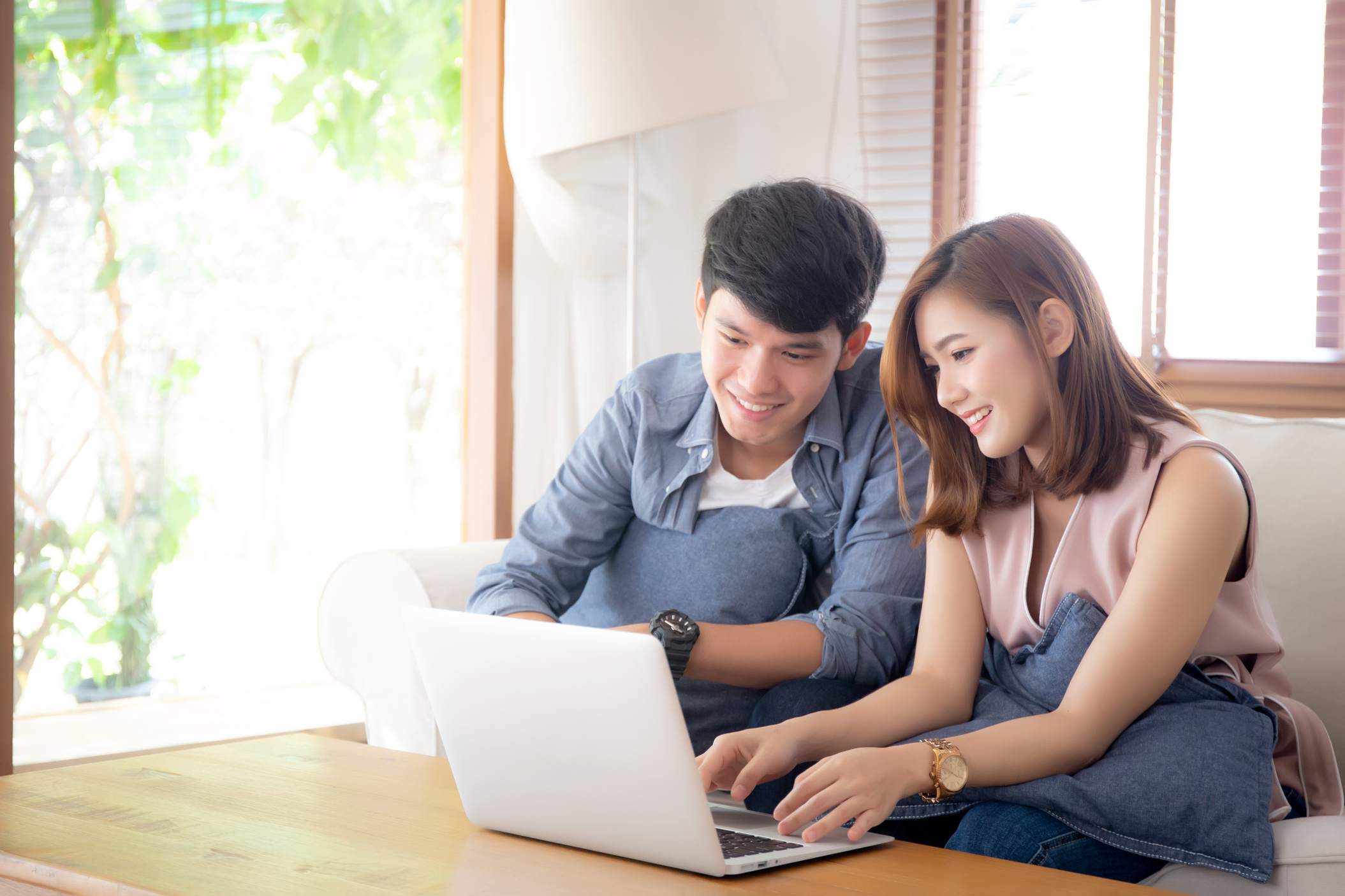 Young Couple Relaxing Indoors Using Laptop